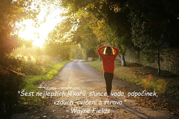 Žena jdoucí po cestě v přírodě s citátem pro zdraví od Wayna Fieldse.