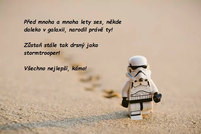 Bílá lego postava stormtroopera ze Star Wars jdoucí po poušti s nápisem.